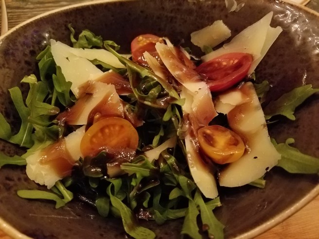 House arugula salad with shaved aged provolone, grape tomatoes, and a sweet balsamic glaze dressing